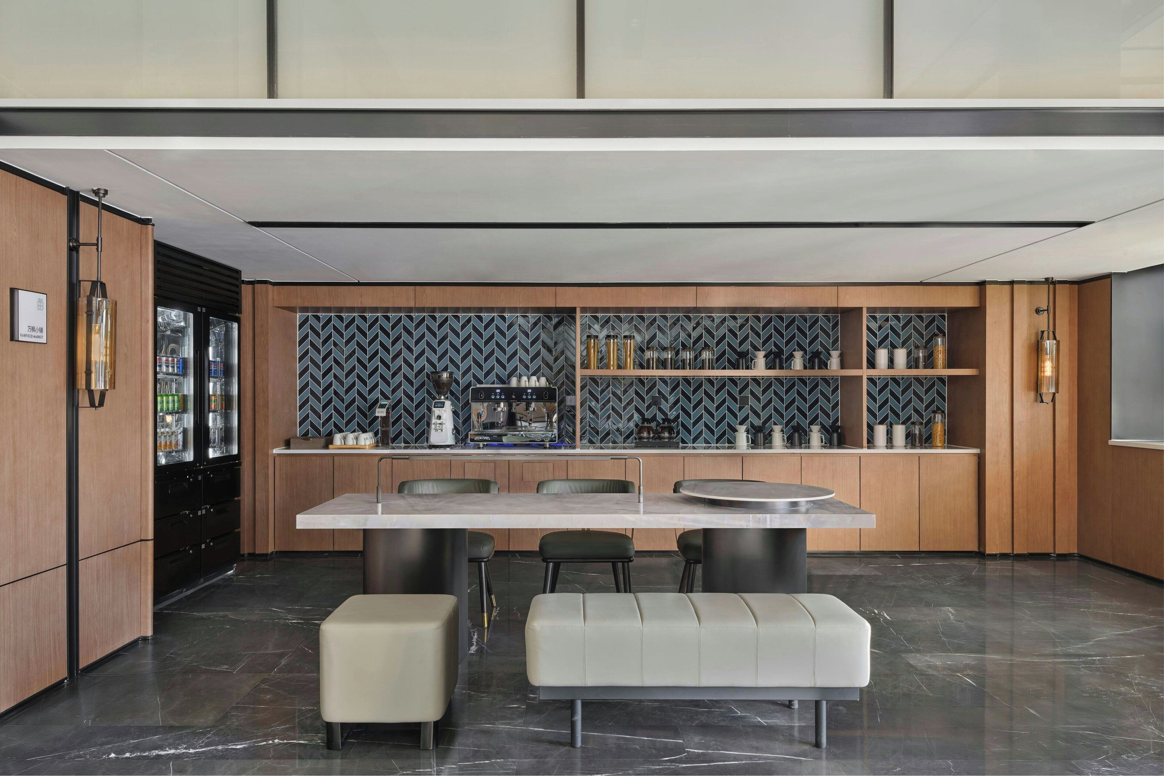 Une cuisine moderne dotée d’un îlot central, de meubles en bois et d’un dosseret en carreaux disposés en motif chevron.
