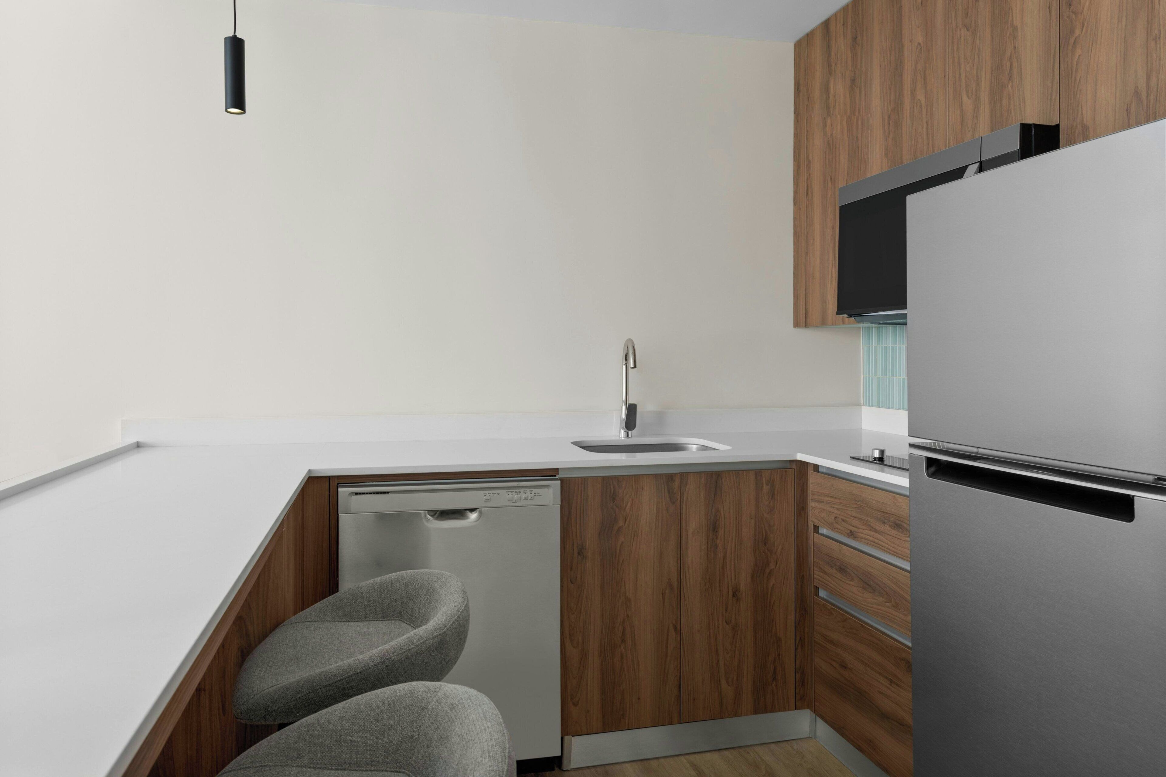 A modern kitchen with a dishwasher, a sink, and a built-in refrigerator.