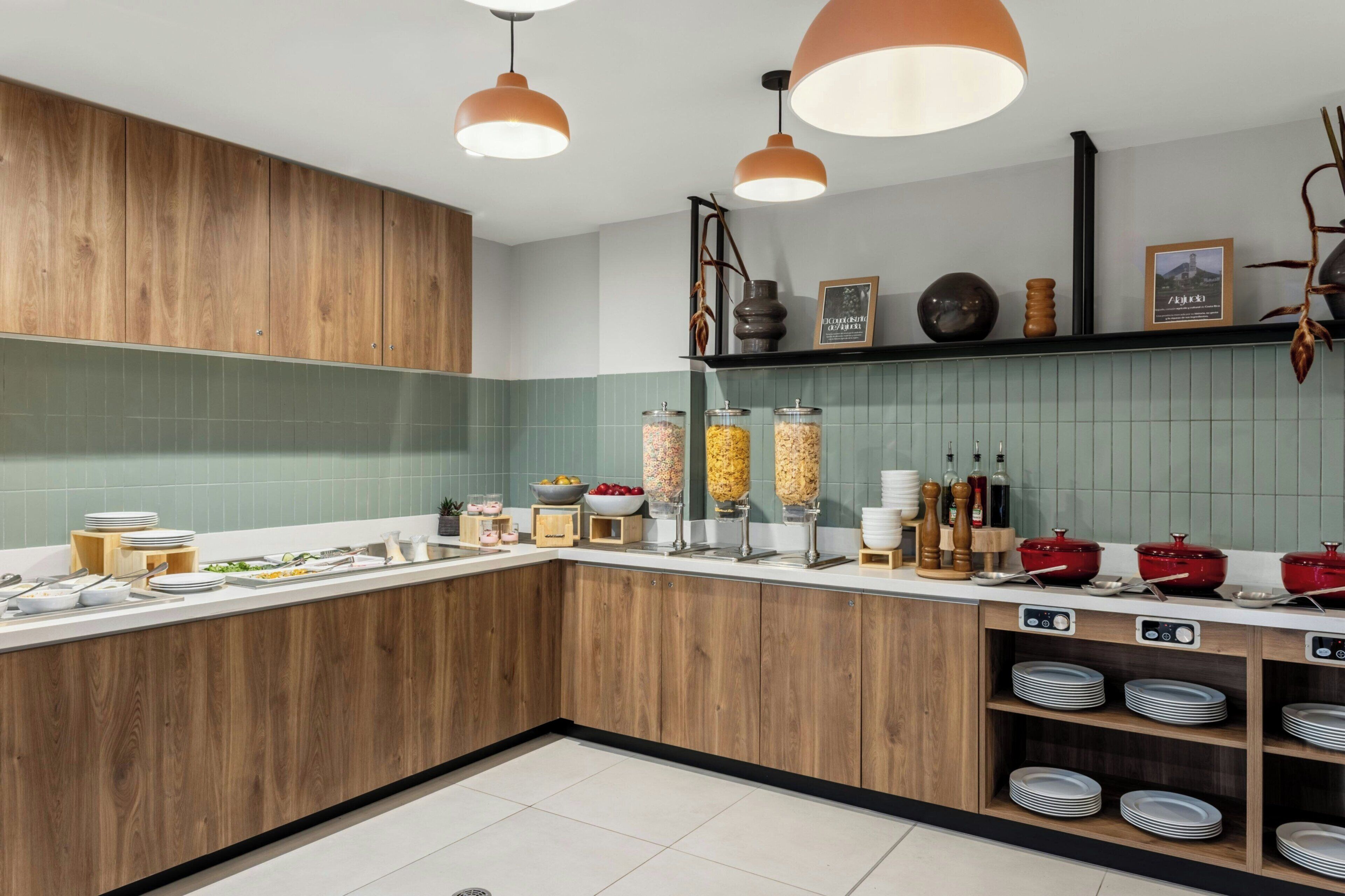 Een keuken met houten kastjes, een betegelde spatwand en divers keukengerei.