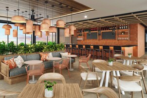A modern bar area with wooden furniture, hanging pendant lights, and a bar counter with bottles.