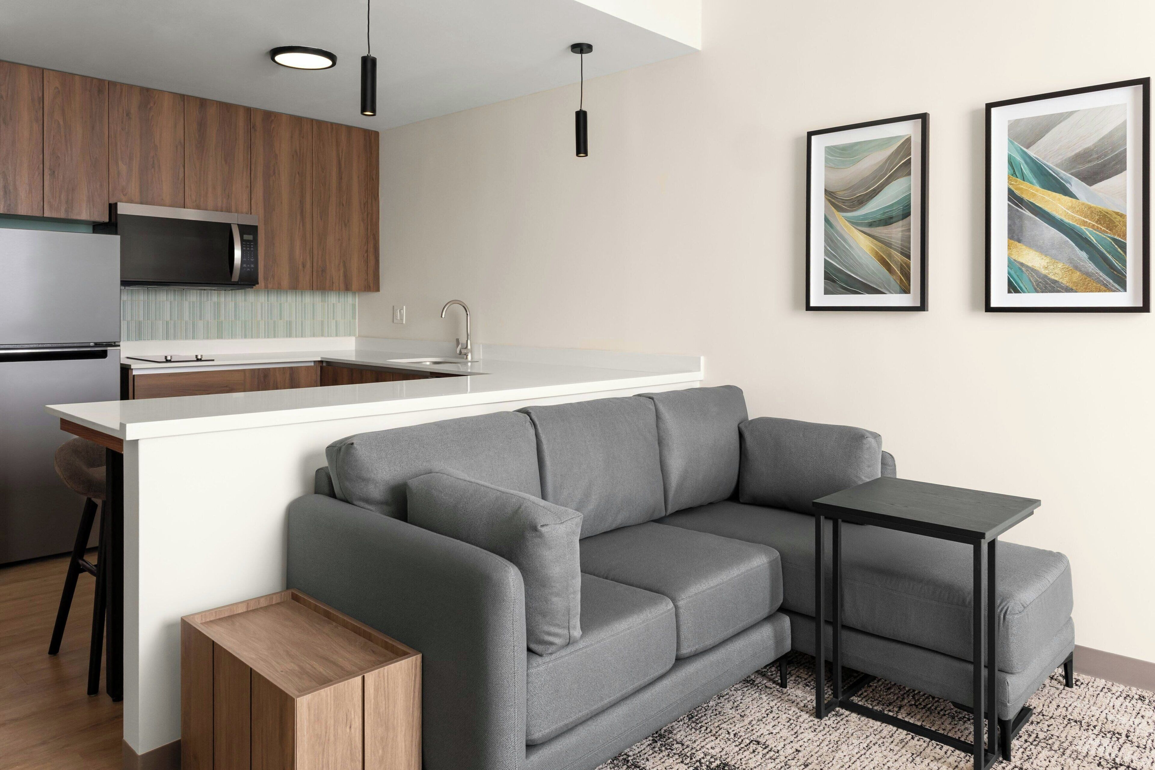 A modern kitchen with a built-in microwave, a sink, and a bar area.