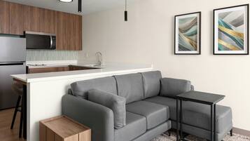 A modern kitchen with a built-in microwave, a sink, and a bar area.