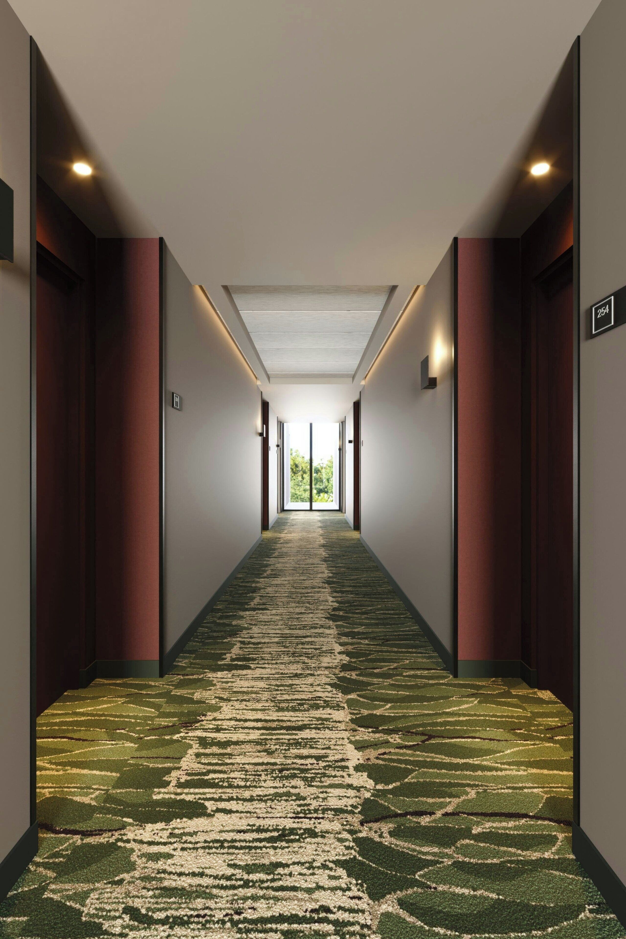 Un pasillo con alfombra estampada, puertas a ambos lados y un letrero que indica la habitación número 204.