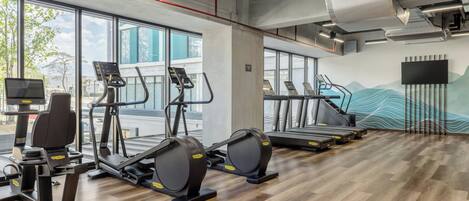 A gym with treadmills, elliptical machines, and weight equipment.