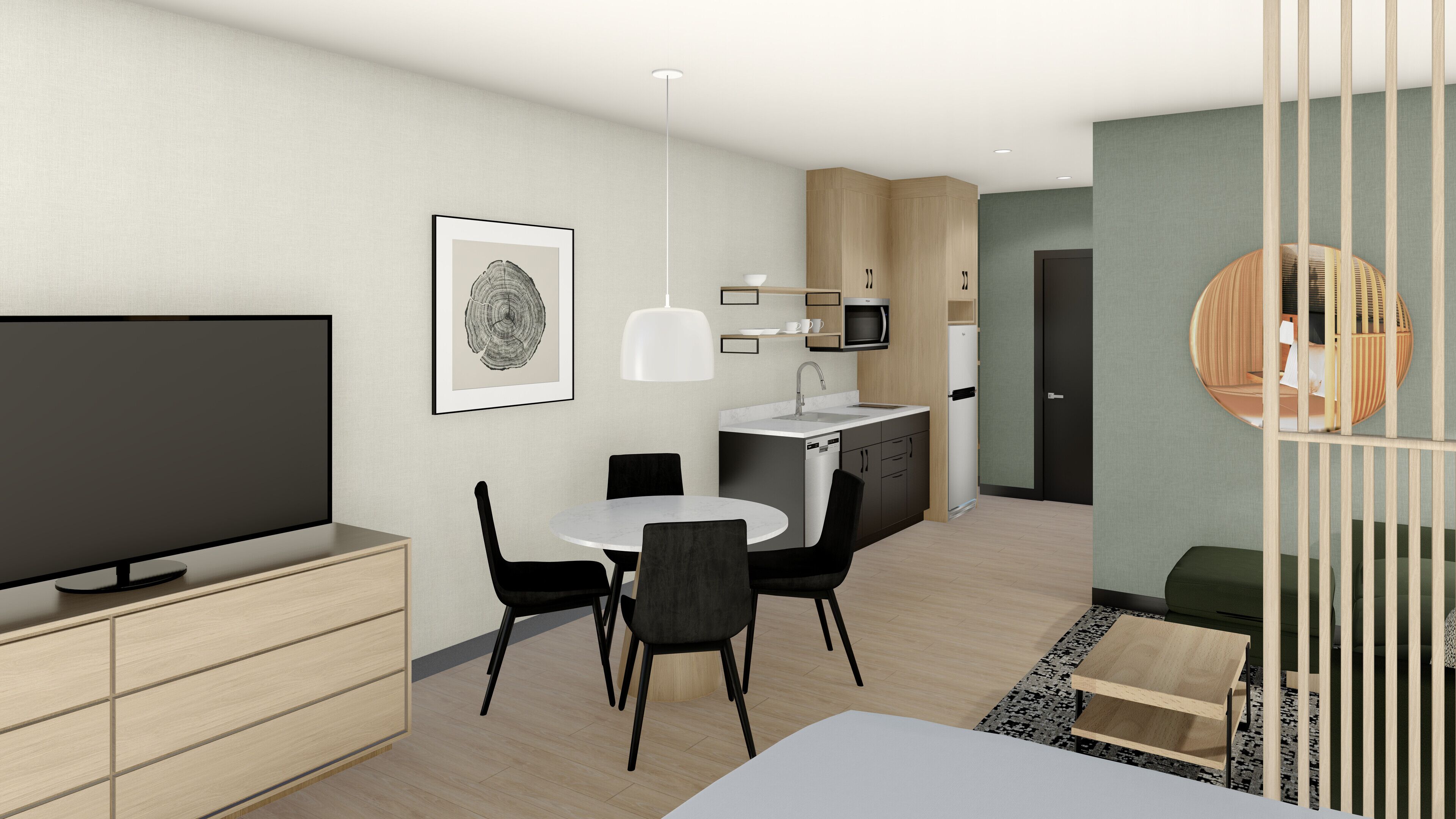 A modern, minimalist living room with a flat-screen TV, a dining area with a white table and black chairs, a kitchen with a microwave and sink, and a green accent wall.