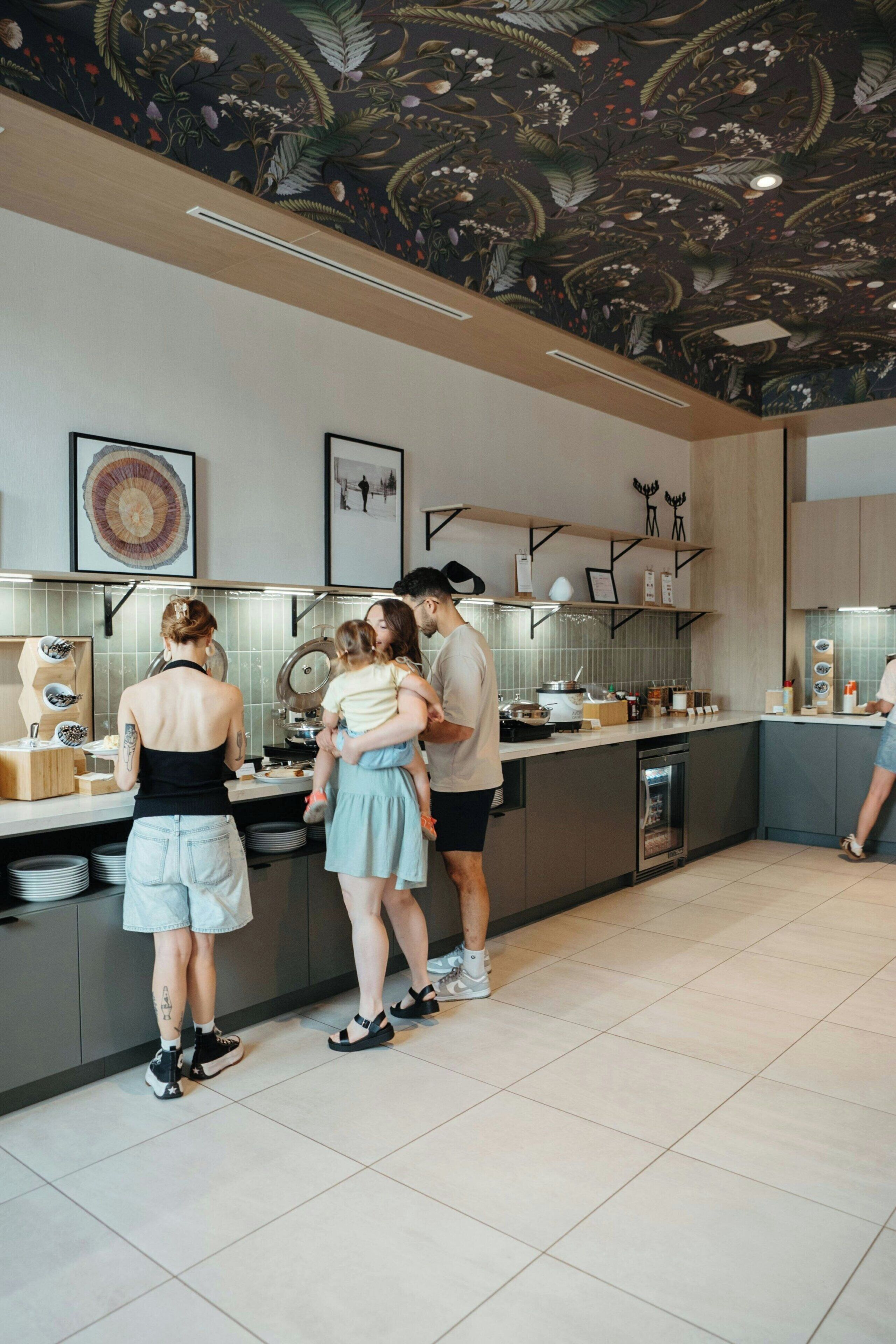Een moderne keuken met een centraal eiland, een betegelde spatwand en een decoratief plafond.