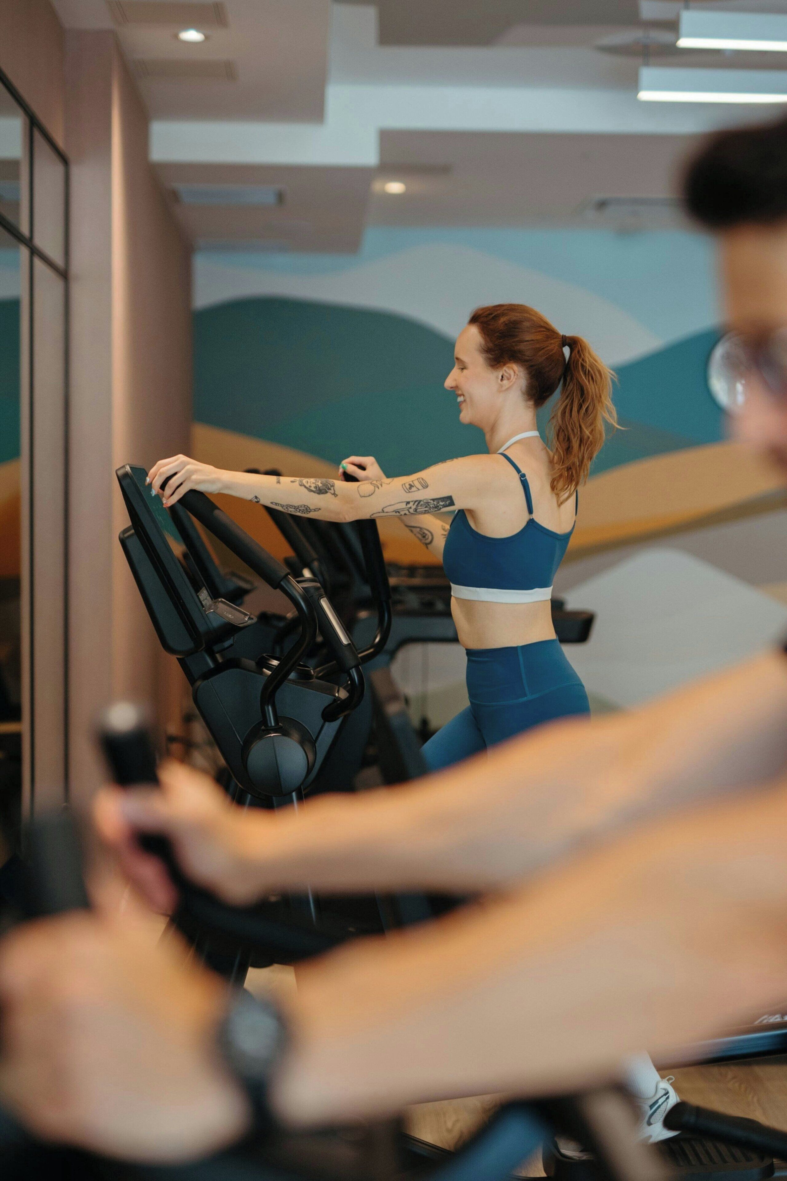 En person som använder en motionscykel i ett gym med modern inredning.