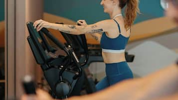 En person som använder en motionscykel i ett gym med modern inredning.