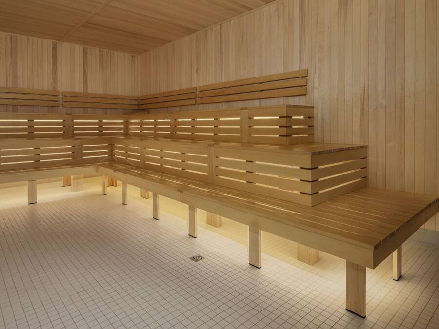 Una sauna con varios bancos y piso de baldosas.