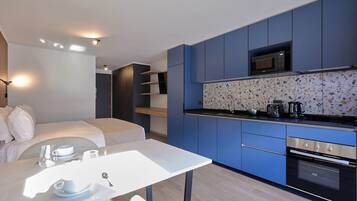 A modern kitchen with blue cabinets, a microwave, and a countertop with a coffee maker.