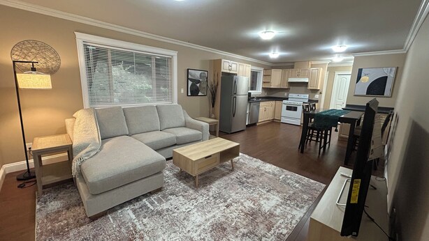 A modern living room with a grey sectional sofa, a wooden coffee table, and a patterned rug.