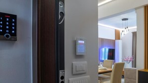 Ein modernes Interieur mit einer digitalen Tastatur, einer Wandbedieneinheit und einem Essbereich mit Fernseher.