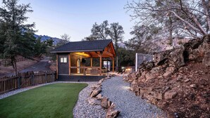 A rustic cabin with a wooden exterior, a stone pathway, and a well-maintained lawn. - Prime Sequoia Stay: Pool • Hot Tub • Sauna • Views (Three Rivers)