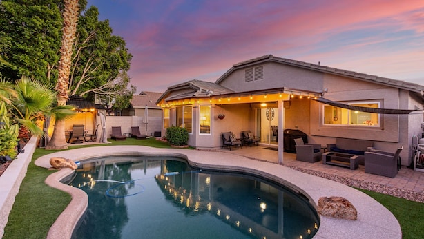 A modern house with a swimming pool, outdoor seating, and a patio area. - Private Pool & Patio: Home in Surprise! (Surprise)