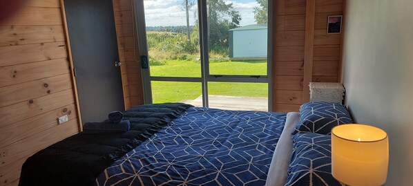 Ein Schlafzimmer mit einem großen Bett, einem Nachttisch und einem Beistelltisch mit einer Lampe.