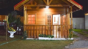Eine Holzhütte mit Veranda, einer sichtbaren Tür und einem Fenster.