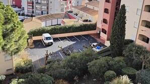 A residential area with a parking lot, a Ferris wheel, and a marina in the background. - Apartment T2 45M2 exceptional view Fitted kitchen shower room living room loggia (Agde)