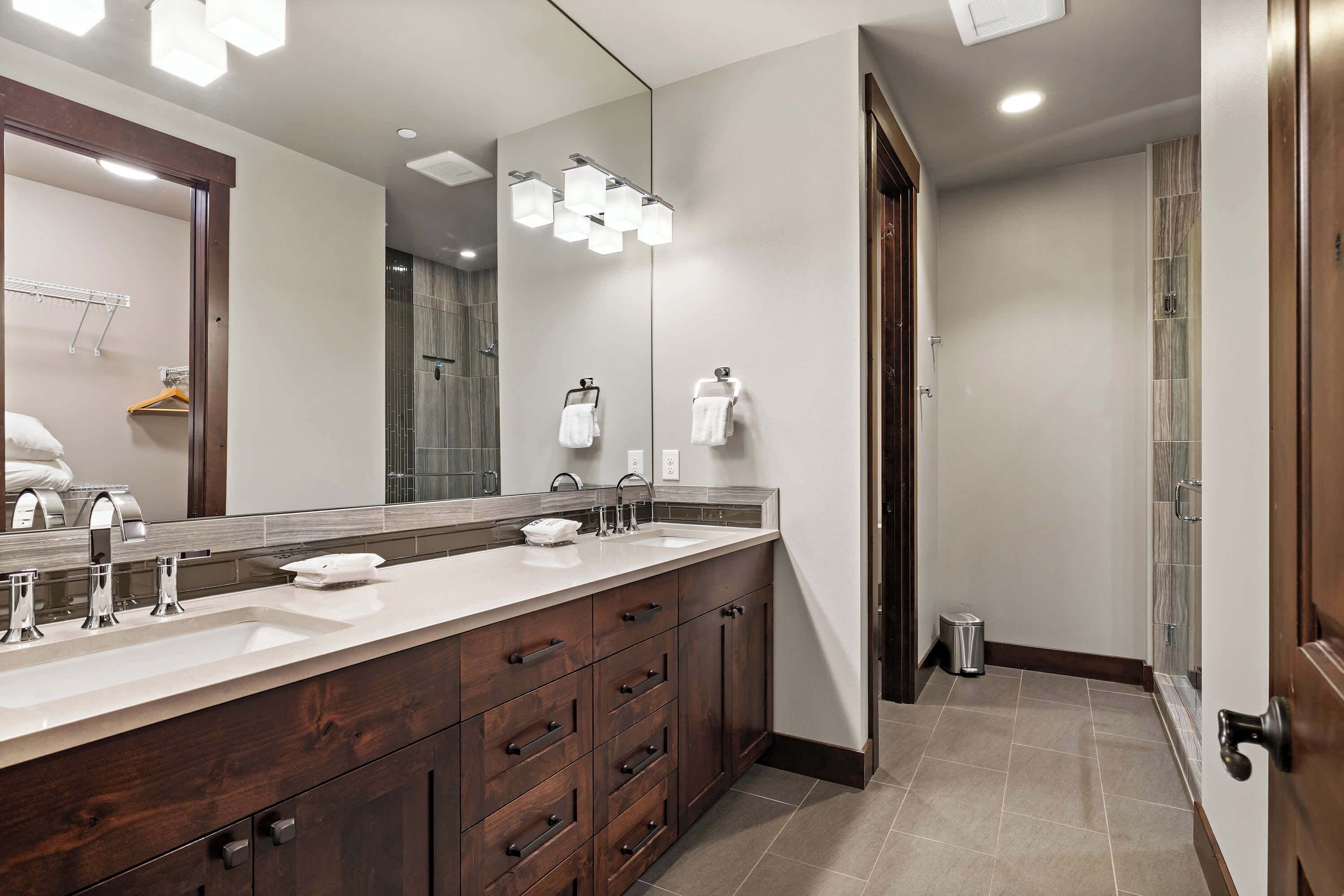 A modern bathroom with a double sink vanity, a large mirror, and recessed lighting.