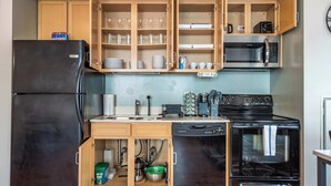 A compact kitchen with a refrigerator, microwave, stove, and built-in cabinets. - Downtown Chicago Stay with Free In & Out Parking 3 (Chicago)