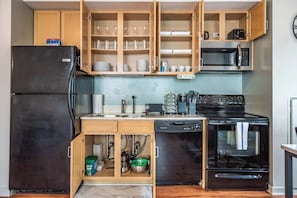 A compact kitchen with a refrigerator, microwave, stove, and built-in cabinets. - Downtown Chicago Stay with Free In & Out Parking 3 (Chicago)