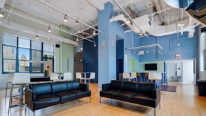 A spacious lobby with leather sofas, a coffee table, and a TV screen. - Downtown Chicago Stay with Free In & Out Parking 3 (Chicago)