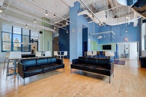 A spacious lobby with leather sofas, a reception desk, and a large window offering a city view. - Downtown Chicago Stay with Free In & Out Parking 1 (Chicago)