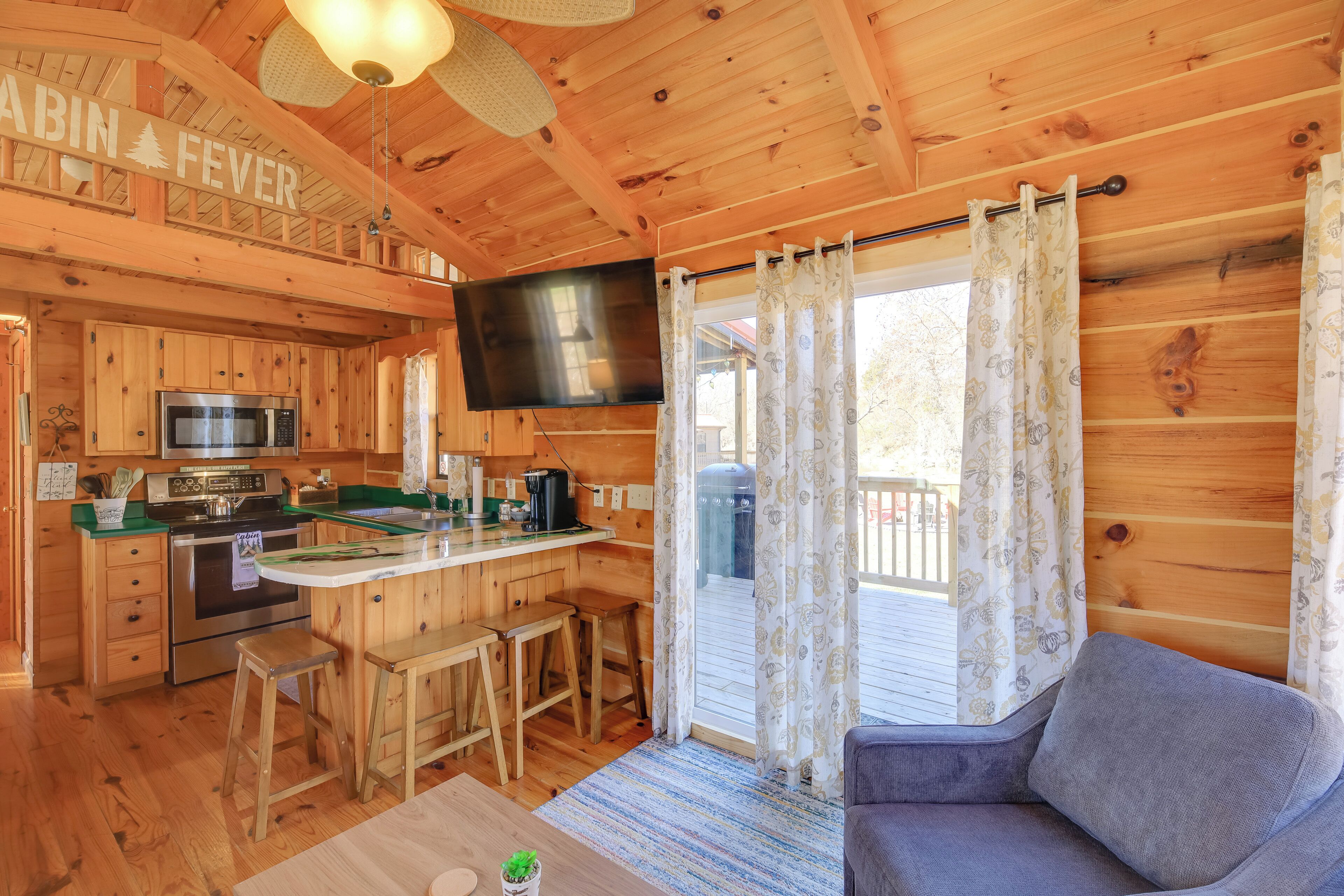 A cabin interior with a kitchen, dining area, and a living room.