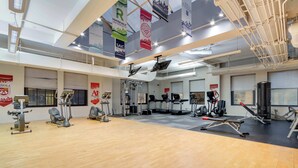 A gym with various exercise equipment, banners, and a wooden floor. - Downtown Chicago Stay with Free In & Out Parking 6 (Chicago)