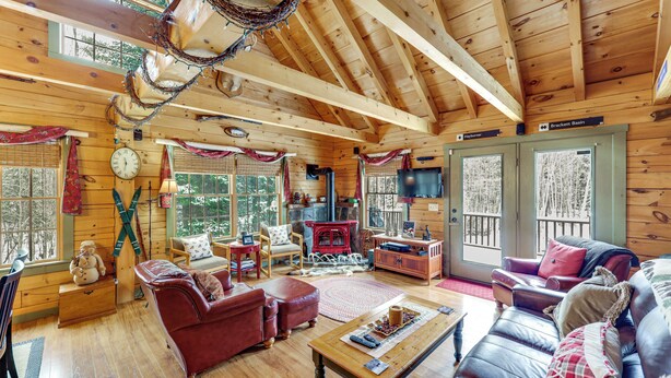A cozy cabin interior with a fireplace, leather furniture, and a wooden ceiling. - Game Room, Deck! Cozy Ski Cabin Near Sugarloaf (Eustis)