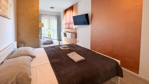 A modern hotel room with a bed, a TV mounted on the wall, and a view of the outdoor area. - Awesome home in Liznjan (Liznjan)