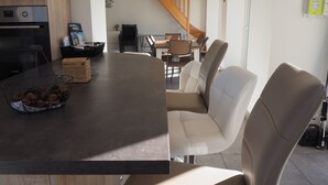 A modern kitchen with a dark countertop, a bowl of snacks, and a coffee machine.