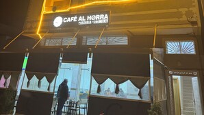 A building with a sign reading "CAFÉ AL HORRA PIZZERIA - CREMERIE" at the entrance. - Fantastic 3-bedroom apartment in cool Oujda for your stay (Oujda)