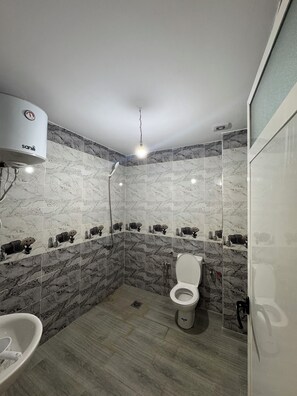 Une salle de bain moderne équipée de toilettes, d’une douche et d’un lavabo.
