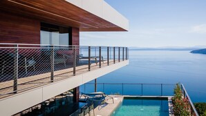 Ein modernes Gebäude mit Schwimmbad und Meerblick.