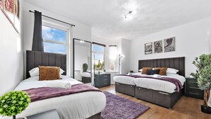 Un dormitorio moderno con dos camas, un ventanal y vistas al exterior.