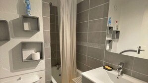 Ein modernes Badezimmer mit Toilette, Badewanne, Waschbecken und Dusche.