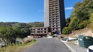 Ein hohes, modernes Gebäude mit flachem Dach und mehreren Balkonen.