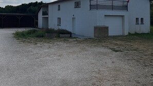 A single-story building with a white exterior, a garage door, and a flag. - Bed and breakfast, with private bathroom, 6kms from Montauban. (Montauban)