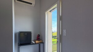 A small room with a television on a stand, a coffee maker, and a sliding glass door leading to an outdoor area. - Bed and breakfast, with private bathroom, 6kms from Montauban. (Montauban)