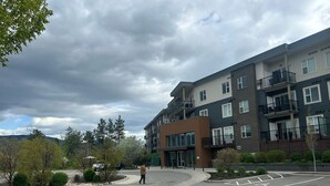 A multi-story residential building with a modern design, featuring balconies and large windows. - 5 min walk to university with stunning mountain views (Kelowna)