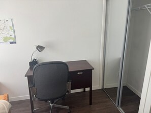 Ein kleiner Büroraum mit Schreibtisch, Stuhl und einer Karte an der Wand.