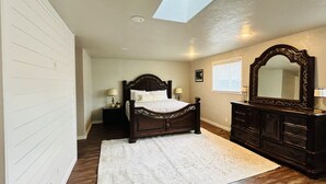 A bedroom with a bed, dresser, and mirror. - Bonanza Blast in SW Boise (Boise)