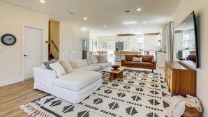 A spacious living room with a white sofa, a patterned rug, and a wooden coffee table. - Walk to Keansburg Beach! Family Home w/ Pool (Keansburg)