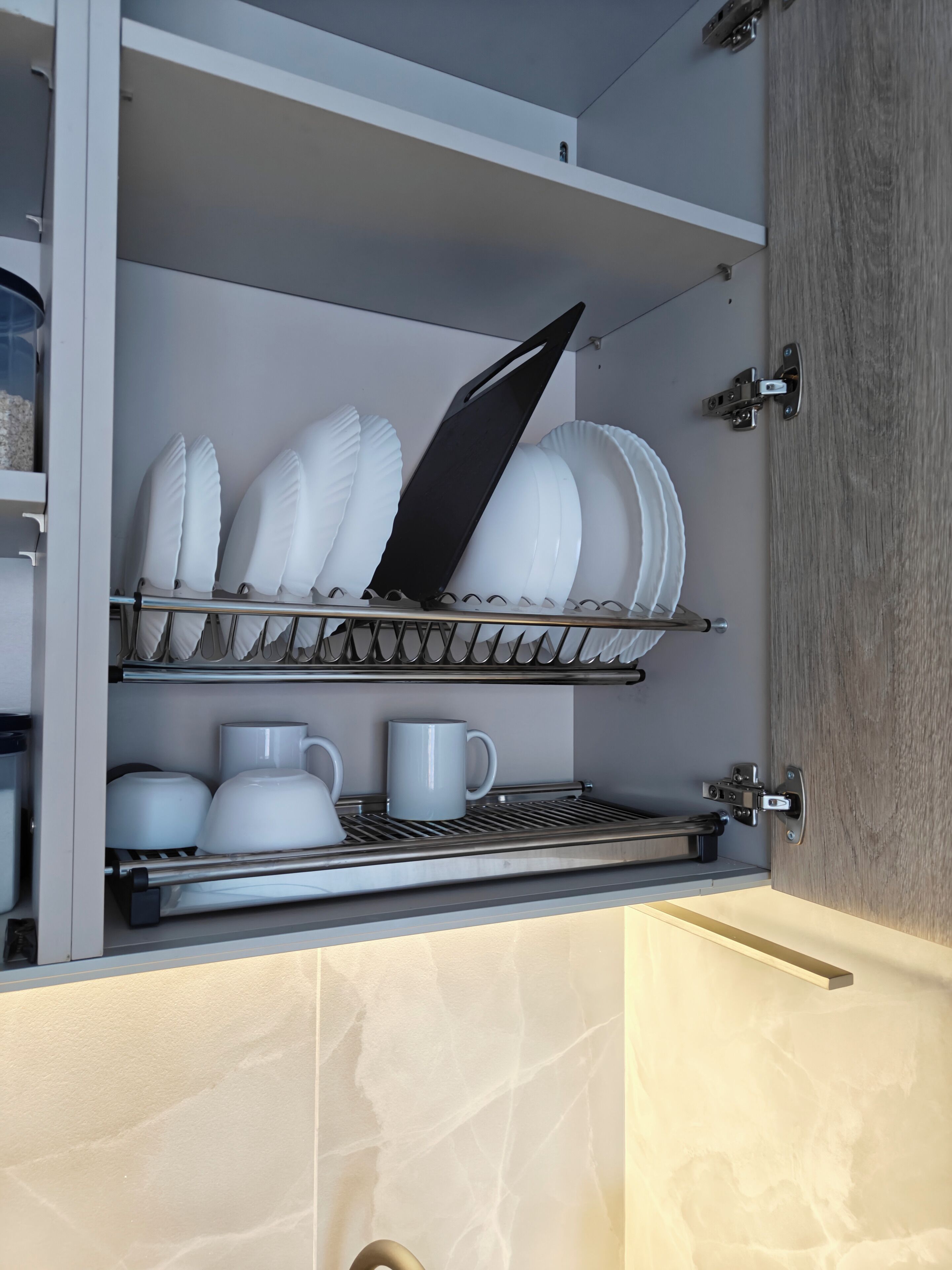 Une cuisine équipée d’un égouttoir à vaisselle intégré pour les assiettes et les bols, d’une machine à café et d’un four à micro-ondes.