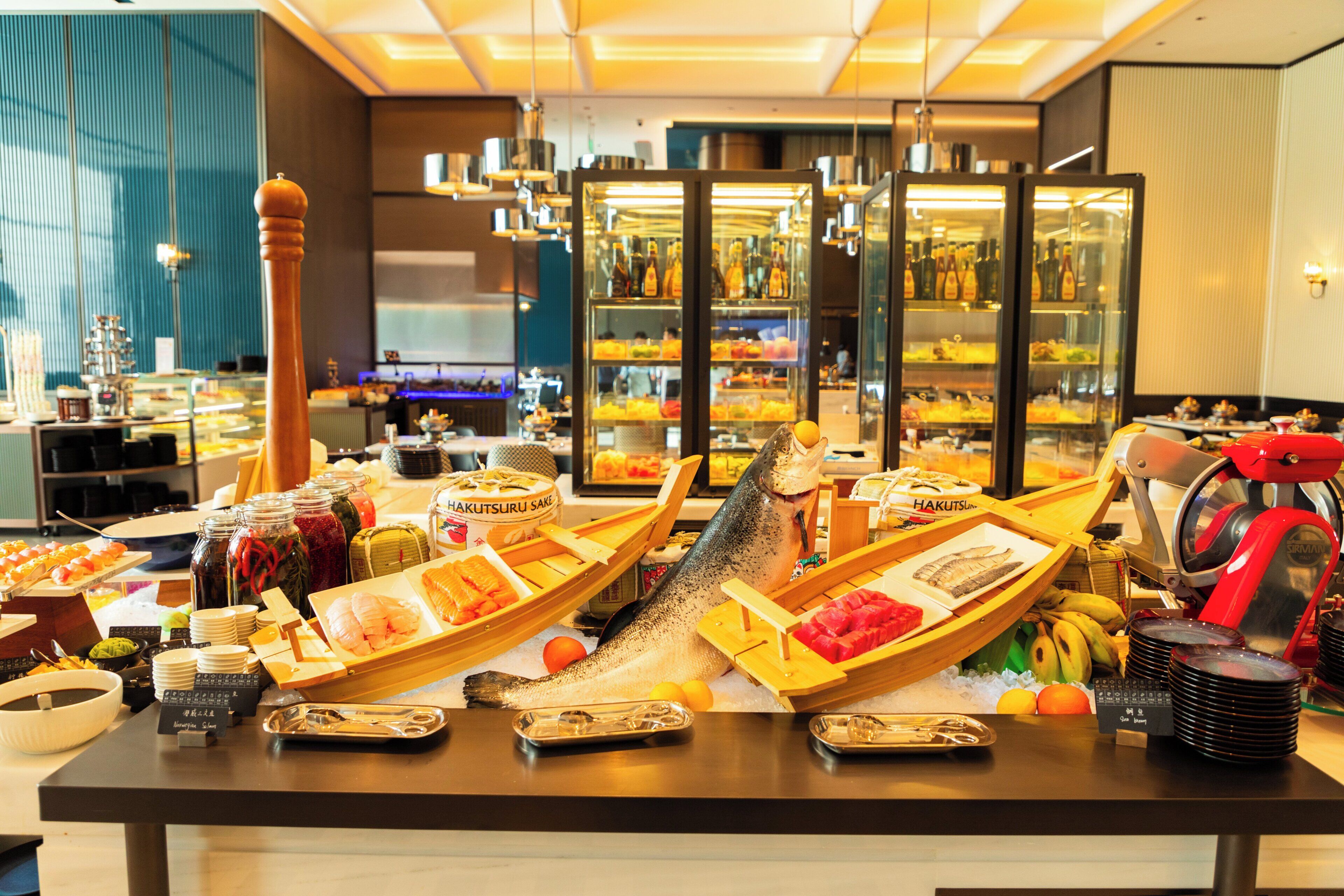 Une table de buffet proposant des fruits de mer, des fruits et diverses sauces.