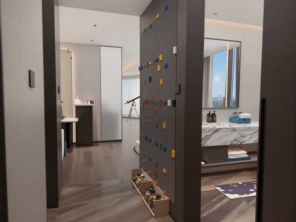Ein modernes Hotelzimmer mit großem Fenster, Marmorplatte im Badezimmer und einer Wand mit einem Lochpaneel und bunten Gegenständen.