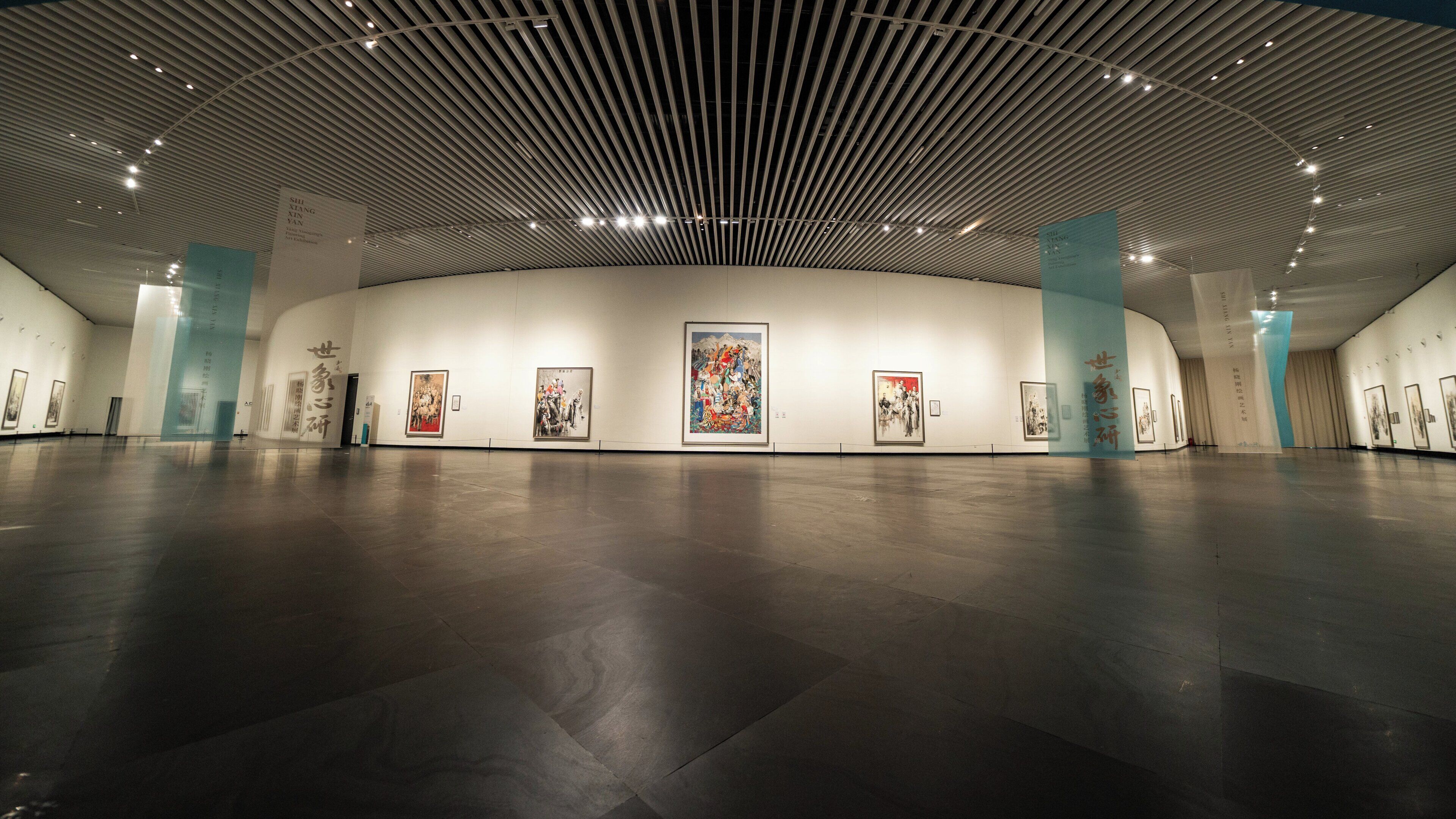 A spacious art gallery with a high ceiling and modern lighting.