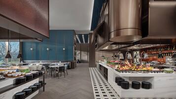 Una cocina moderna con una isla central, electrodomésticos de acero inoxidable y una variedad de alimentos a la vista.
