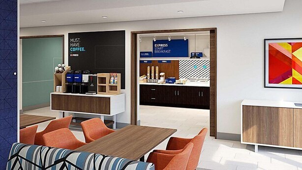 Een moderne hotel lobby met een koffiehoek, zithoek en een groot abstract schilderij.