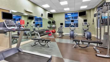 Een fitnessruimte met loopbanden, gewichtmachines en elastische fitnessballen.